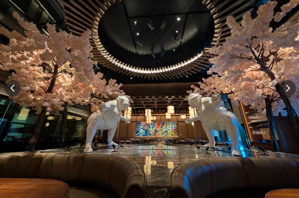 WAKUDA dining room with cherry blossom trees and sculptural tiger statues